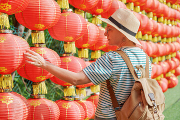 Female tourist enjoying view of traditional Chinese red lanterns