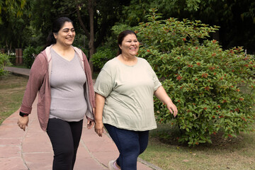 Obraz premium Happy indian oversized woman walking and spending leisure time in the morning at park