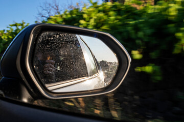 photographing through the right mirror of the car. Traveling by car