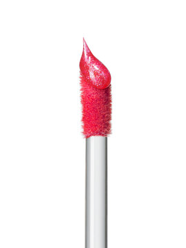 Shimmering pink lip gloss texture on top of brush isolated on white background. Smudged cosmetic lipgloss product drop Makeup swatch product sample