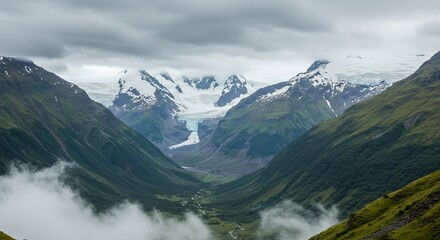 Naklejka premium Breathtaking glacial valley landscape snow capped peaks green mountains cloud cover aerial view