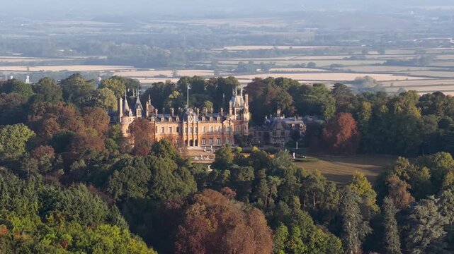 Aerial view of the historic Waddesdon Manor surrounded by lush forests in Buckinghamshire, England