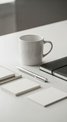 A clean, minimalist workspace presentation featuring a white mug, a black notebook, and blank notepads, set on a white table.