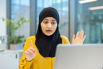 Muslim businesswoman having video call on laptop in office