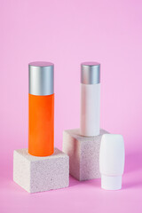 Skin care or sunscreen cosmetic with stylish props on pink background.