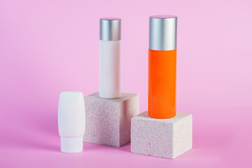 Skin care or sunscreen cosmetic with stylish props on pink background.
