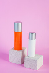 Skin care or sunscreen cosmetic with stylish props on pink background.