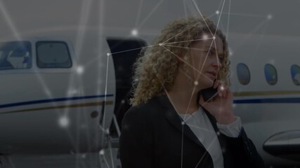Animation of network of connections over businesswomen using smartphone at the airport - Powered by Adobe