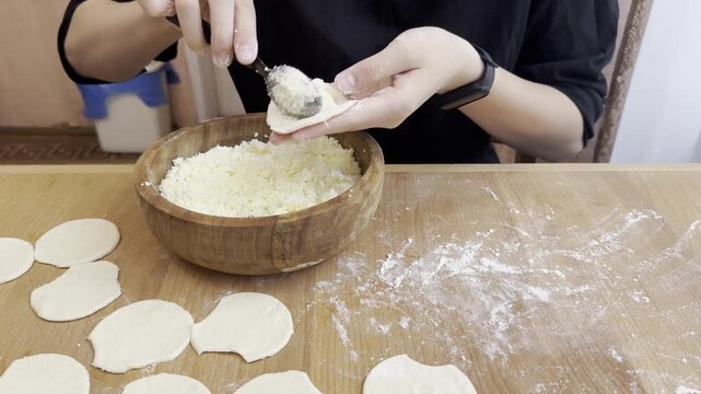molding Ukrainian dumplings from dough and cheese