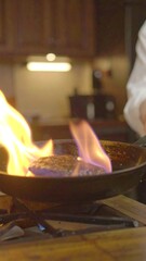Flaming burger patty in a pan