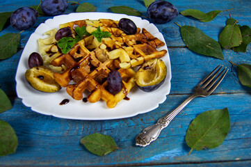 fresh waffles with syrup and ripe plums
