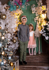 Family portrait in festive clothes against the backdrop of golden lights and Christmas decor.