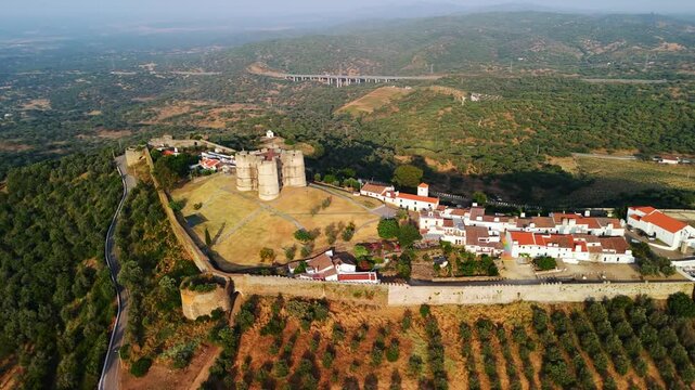 Aerial pan right reveals hilltop Castelo de Evoramonte and walled &Eacute;vora Monte