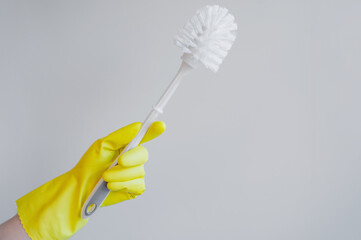 Toilet Brush in Yellow Rubber Glove Isolated on White