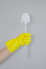 Toilet Brush in Yellow Rubber Glove Isolated on White