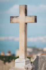Stone cross stands tall against the serene backdrop of the sea and a clear sky, evoking a sense of peace and reflection amidst nature's beauty