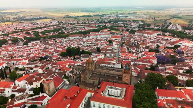 Aerial orbit left circles &Eacute;vora Cathedral above red rooftops of the historic center