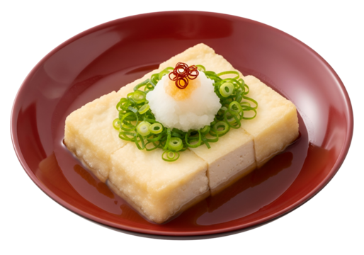 A close-up view of savory tofu, delicately arranged on a rich burgundy plate, garnished with scallions and a hint of spice.