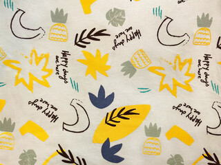 Playful fabric with tropical elements, abstract leaves, pineapples, and cheerful text “Happy days...