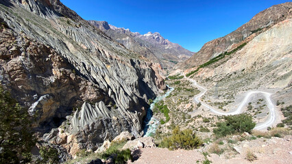 Beautiful mountain landscape. A rocky gorge in Tajikistan. Ridges, hills, and road serpentine slopes. Traveling through Asia in the hot summer
