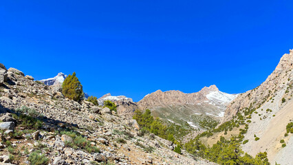 Fototapeta premium Climbing in the Fan mountains of Tajikistan. Trekking and hiking. A walk in the fresh air in the mountains of Asia. Rocky ridges, hills and cliffs