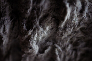 Extreme close up of old gray handmade paper clay with a structure and rough texture. Paper recycling. Selective soft focus, shallow depth of field.
