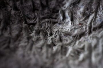 Extreme close up of old gray handmade paper clay with a structure and rough texture. Paper recycling. Selective soft focus, shallow depth of field.