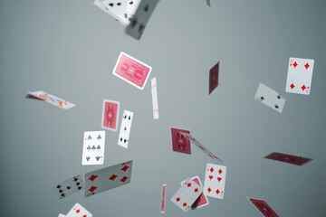 Playing cards falling and scattering in mid air against a gray background