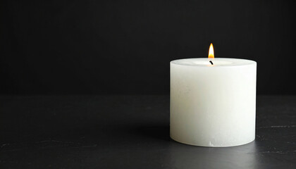 A single white candle with a flickering flame against a black background.