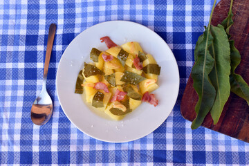 Stew made with sorrel (Rumex spp.), potato, ham and garlic
