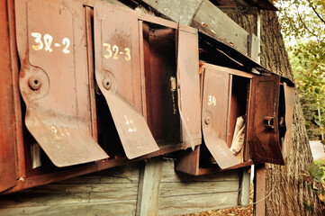Old rusty metal mailboxes for traditional paper mail, vintage tones applied