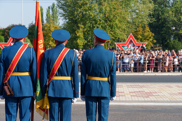 A soldier in formal uniform stands in formation during a parade