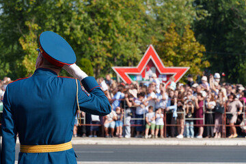 A soldier in formal uniform stands in formation during a parade