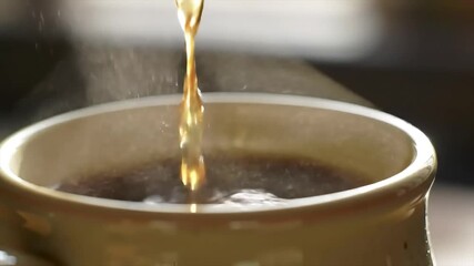 A stream of rich, dark coffee gracefully descends into a rustic mug, creating a comforting steam that promises a warm, invigorating start to the day