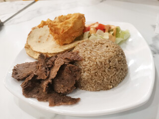 A delicious doner kebab platter with rice, salad, and crispy snacks for a culinary delight
