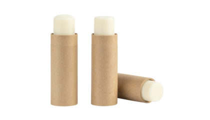 Three eco-friendly cardboard lip balm tubes containing white balm sticks, two standing upright and one resting on its side.