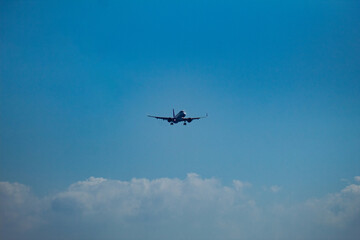 Passenger Airplane Flying in Blue Sky with Clouds