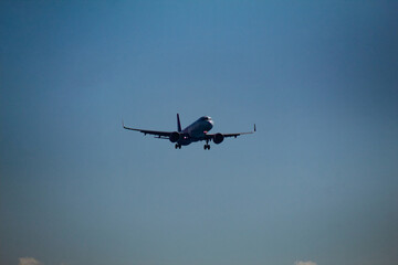 Commercial Passenger Jet Flying Through Clouds in Blue Sky