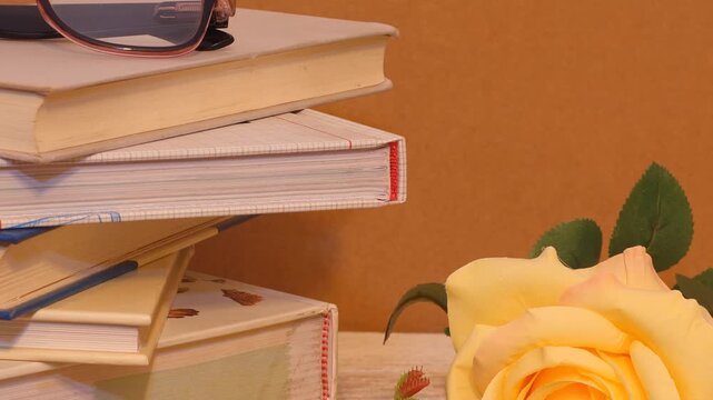 libros amontonados rosa amarilla gafas 