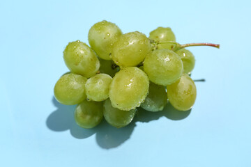 Sweet green grapes on blue background