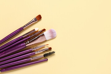 Obraz premium Makeup brushes on yellow background