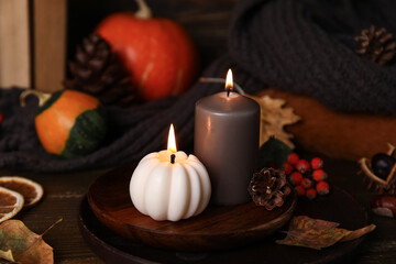 Beautiful autumn composition with candles and pumpkins on brown wooden background