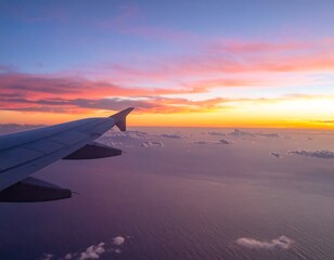 Obraz premium Airplane wing at sunset over clouds and ocean