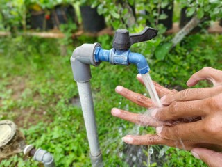 Washing Hands Under Outdoor Faucet: Promoting Hygiene, Health, and Freshness in a Natural Green...