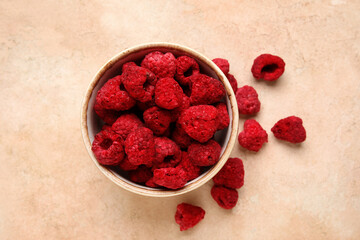 Bowl of dehydrated raspberries on beige background