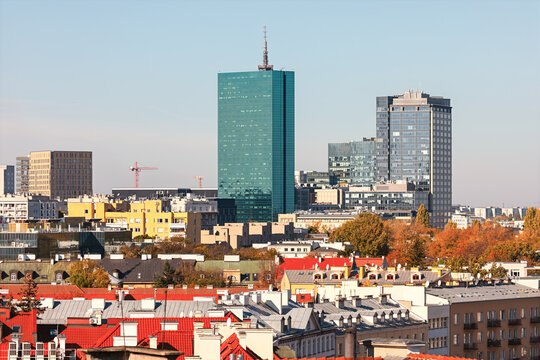 Fototapeta Warsaw skyline featuring modern glass skyscrapers alongside colorful rooftops of historic buildings. Vibrant cityscape captures the dynamic blend of tradition and progress in Poland capital