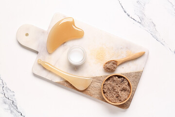 Beautiful composition with tray, facial massage tools and sea salt on marble background