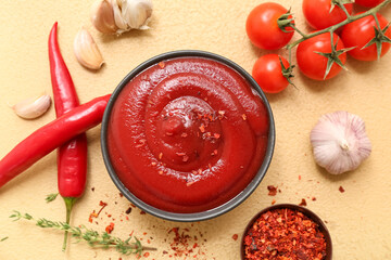 Bowl of chili sauce and different ingredients on yellow background