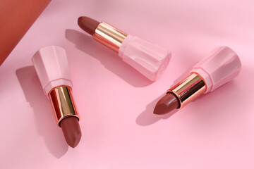 Beautiful brown lipsticks on colorful background, closeup