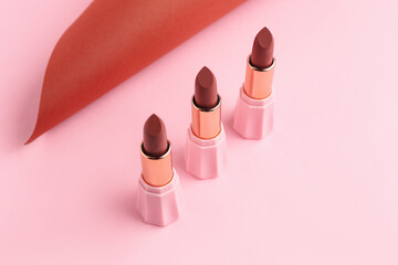 Beautiful brown lipsticks on colorful background, closeup